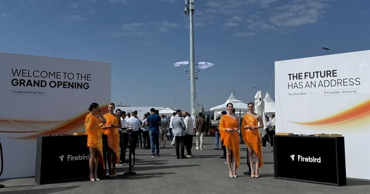 Signage at the entrance to the Firebird AI factory opening in Hrazdan: one board reads Welcome to the Grand Opening, the other reads The future has an address, you are here, Hrazdan, Armenia, with a mobile mast standing behind the guests.