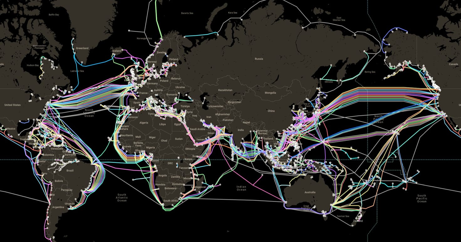 World map of submarine cables as coloured routes on a dark ocean.