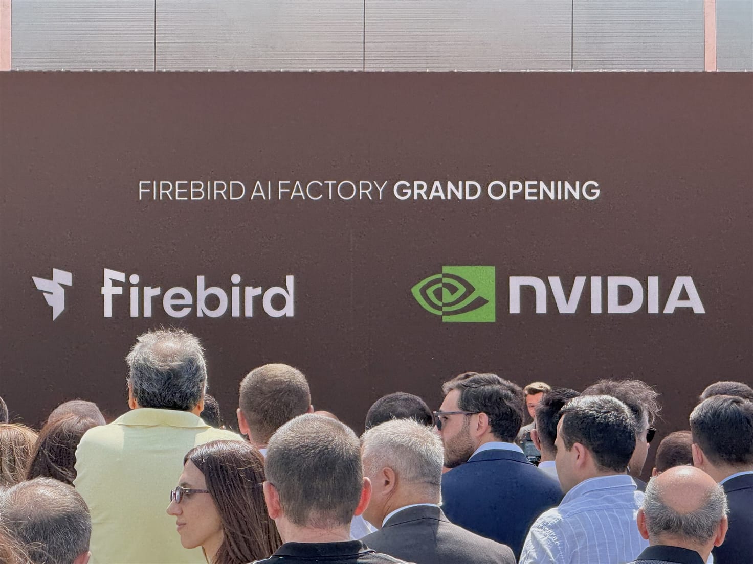 The stage wall reading Firebird AI Factory Grand Opening with the Firebird and NVIDIA logos above a packed crowd.