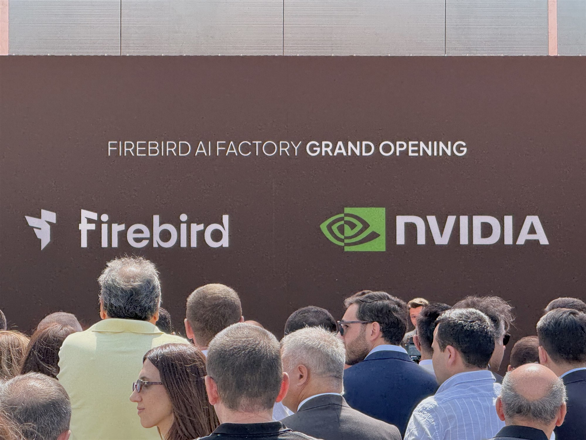 The stage wall reading Firebird AI Factory Grand Opening with the Firebird and NVIDIA logos above a packed crowd.